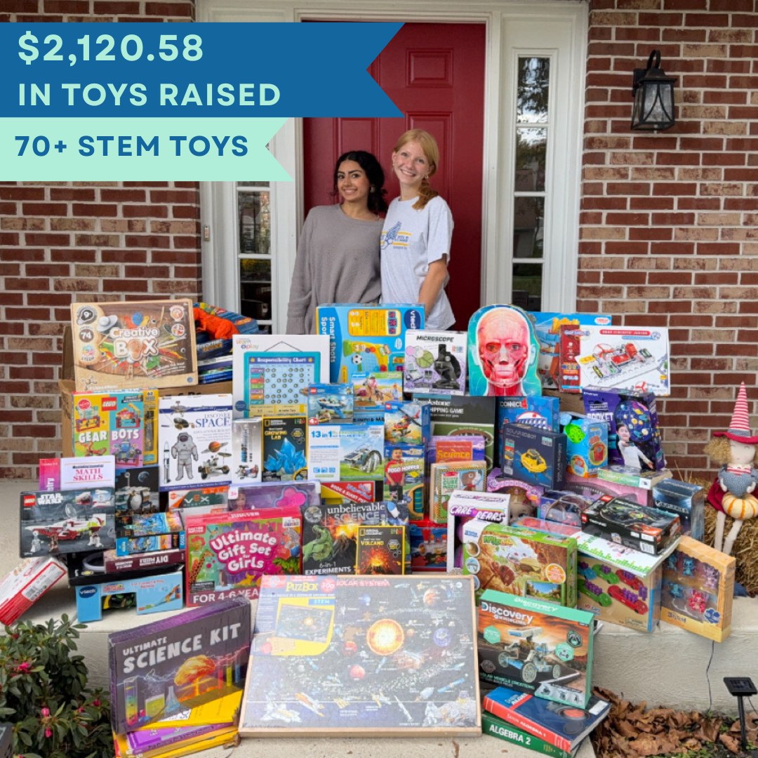 STEM Spark Initiative's two founders behind a large pile of donated STEM toys, with a caption reading 2,120 dollars in toys raised and 70-plus STEM toys.